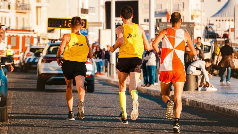 three people running in a road